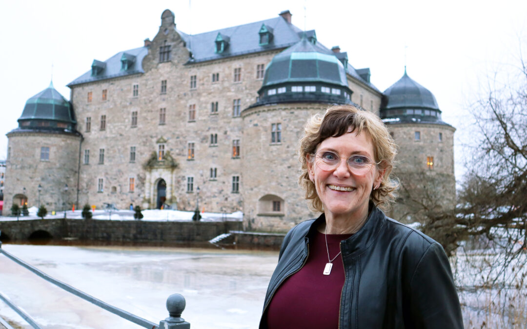 Katrina Hansson står framför slottet i Örebro och ler.